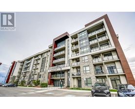 A modern apartment building with a parking lot in front.