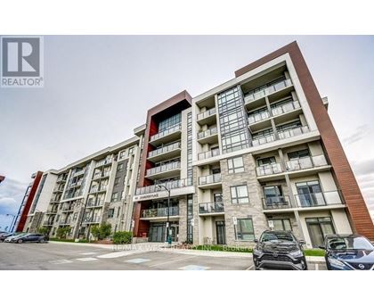 A modern apartment building with a parking lot in front.