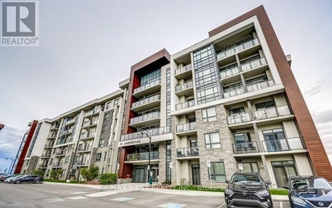 A modern apartment building with a parking lot in front.