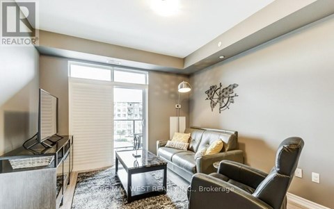 A living room with a black leather couch and a coffee table.