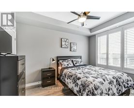 A bedroom with a bed, dresser, and ceiling fan.