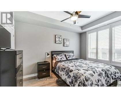 A bedroom with a bed, dresser, and ceiling fan.