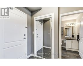 A bathroom with a white door and a mirror.