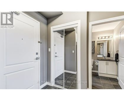 A bathroom with a white door and a mirror.