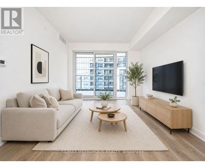 A living room with a couch, a coffee table, and a flat screen TV.