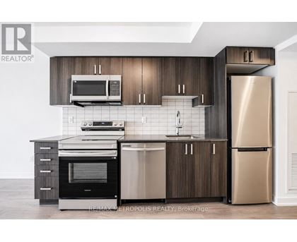 A modern kitchen with dark wood cabinets and stainless steel appliances.