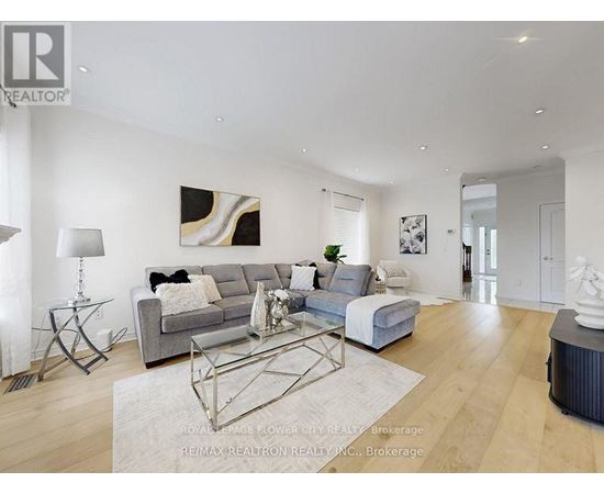 A modern living room with a grey sofa and a glass coffee table.