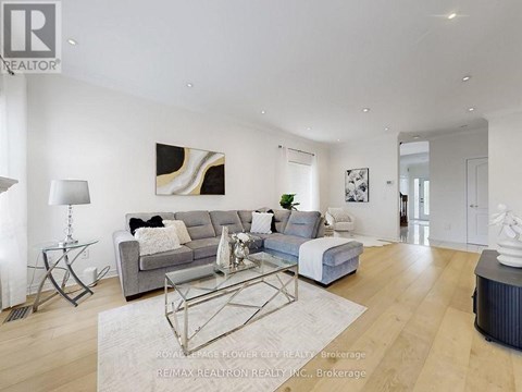 A modern living room with a grey sofa and a glass coffee table.