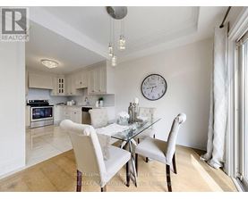 A dining room with a table set for two and a clock on the wall.