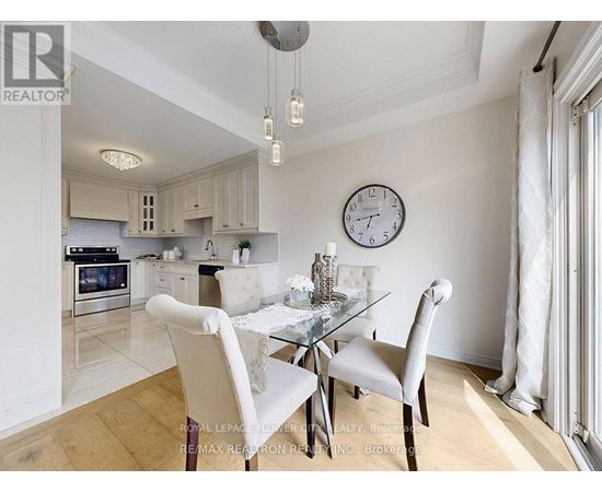 A dining room with a table set for two and a clock on the wall.