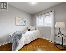 A bedroom with a bed, a lamp, and a painting on the wall.