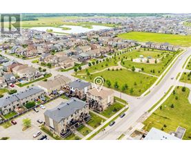 An aerial view of a residential area with a road and houses.