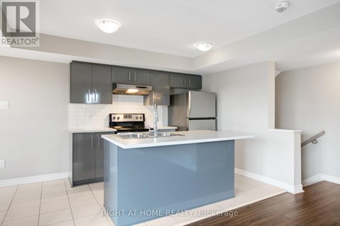 A kitchen with a blue island and stainless steel appliances.