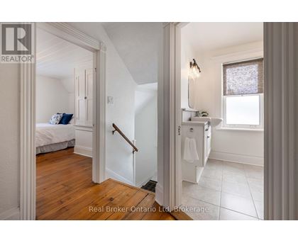 A bedroom with a bed, a dresser, and a window.