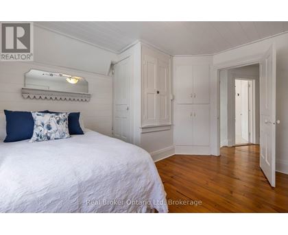 A bedroom with a bed, a dresser, and a mirror.