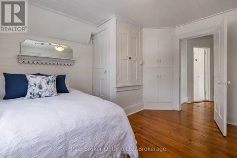 A bedroom with a bed, a dresser, and a mirror.