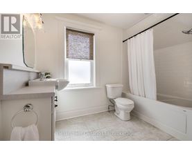 A white bathroom with a toilet, sink, and bathtub.