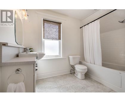A white bathroom with a toilet, sink, and bathtub.