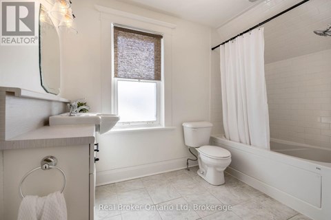 A white bathroom with a toilet, sink, and bathtub.
