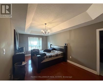 A bedroom with a bed, dresser, and window.