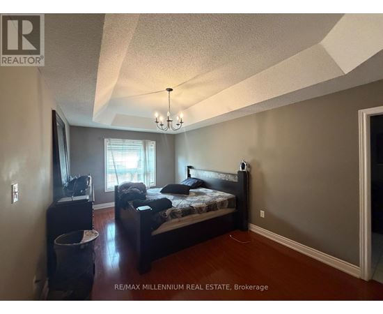 A bedroom with a bed, dresser, and window.