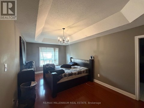 A bedroom with a bed, dresser, and window.