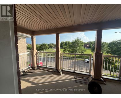 A balcony with a metal railing and a view of a street and trees.