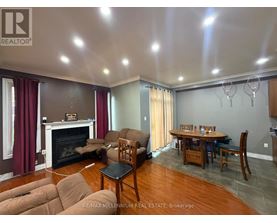 A living room with a fireplace and a dining table.