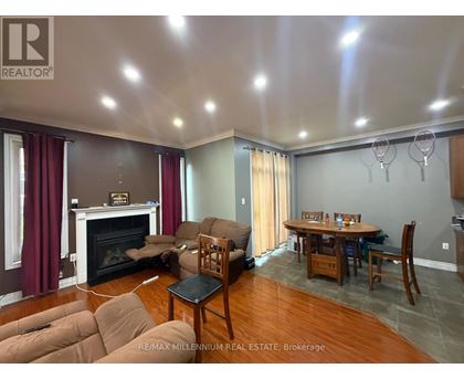 A living room with a fireplace and a dining table.