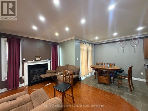 A living room with a fireplace and a dining table.
