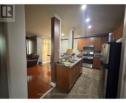A kitchen with wooden cabinets and a refrigerator.