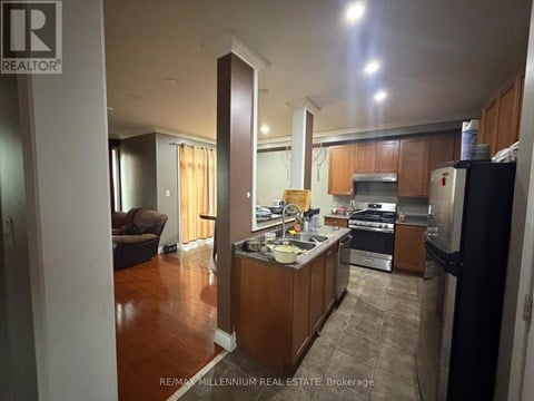 A kitchen with wooden cabinets and a refrigerator.