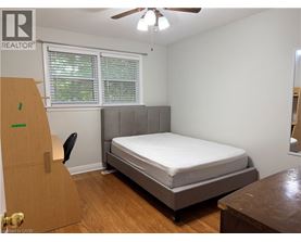 A bedroom with a bed, dresser, and window.