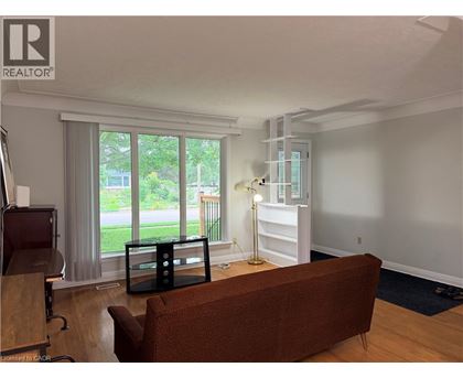 A living room with a brown couch and a wooden floor.
