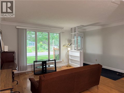 A living room with a brown couch and a wooden floor.