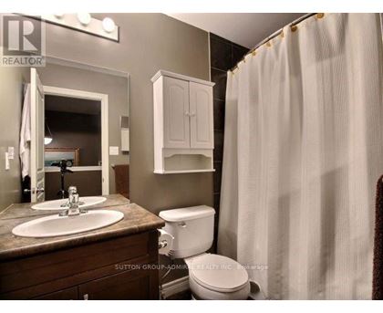 A bathroom with a toilet, sink, and shower curtain.