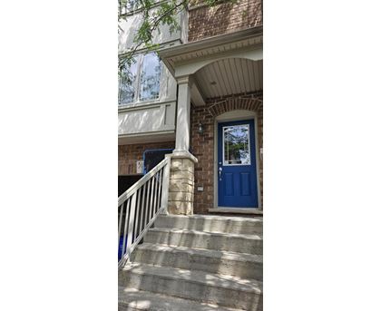 A blue door is on the right side of a white railing.
