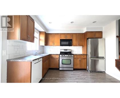 A kitchen with wooden cabinets and a stainless steel refrigerator.