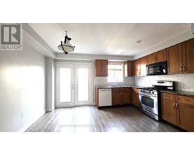 A kitchen with wooden cabinets and a black microwave.