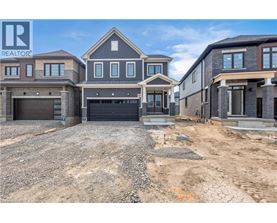 A real estate sign is displayed in front of a row of houses under construction.