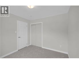 A bedroom with a white door and carpeted floor.