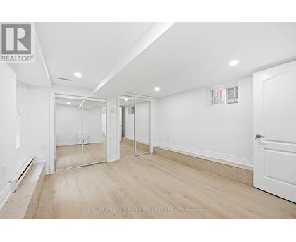 A spacious room with a white door and a mirror on the wall.