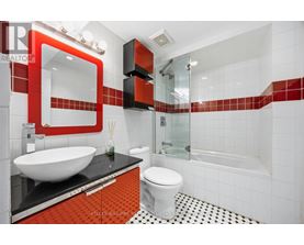 A modern bathroom with a red and black theme.