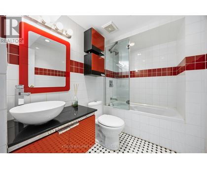 A modern bathroom with a red and black theme.