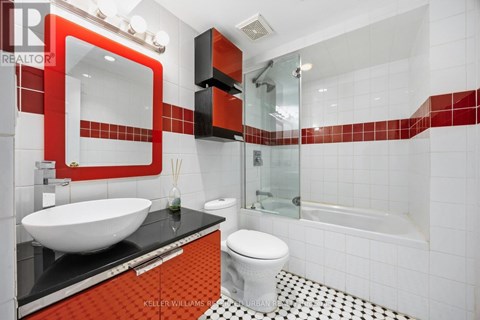 A modern bathroom with a red and black theme.