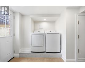 A white kitchen with two ovens and a marble floor.