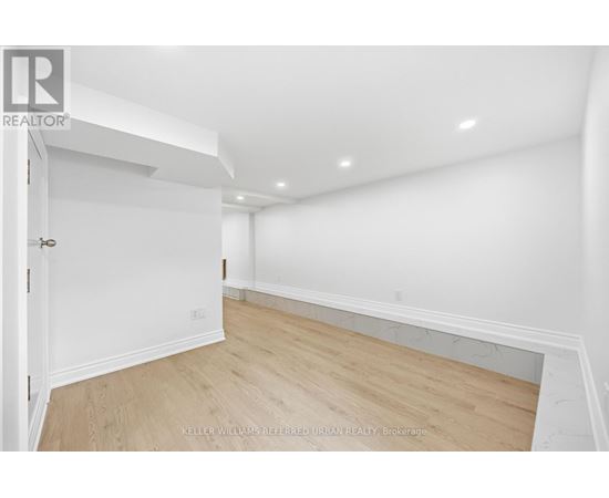 A room with a white wall and wooden floor.