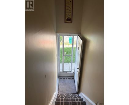A hallway with a door leading to a balcony.