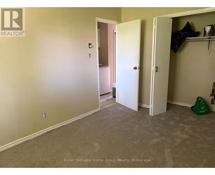 A room with a carpeted floor and two open doors.