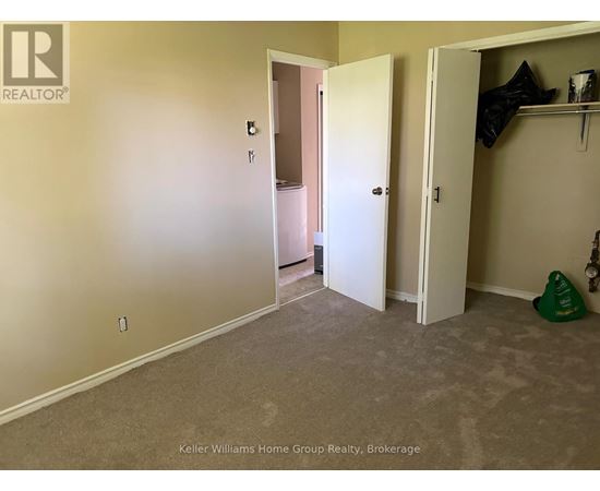 A room with a carpeted floor and two open doors.